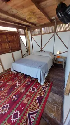 a bed in a room with a red rug at Puerta al Mar Ecolodge Glamping in Tubará