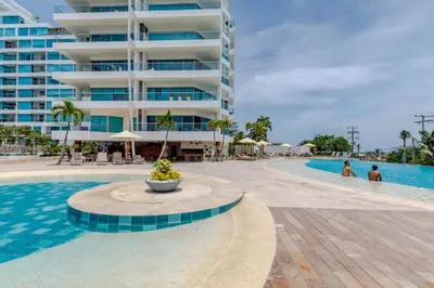 a swimming pool next to a large building at Apartamento de lujo en Cartagena Seaway935 - Morros in Cartagena de Indias