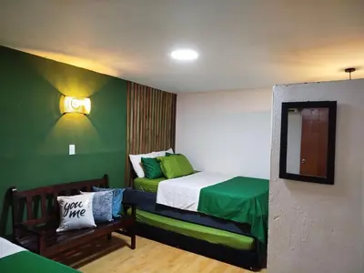 a small room with a bed with green walls at Hb5 Family Room with private bathroom facing the sea in Cartagena de Indias