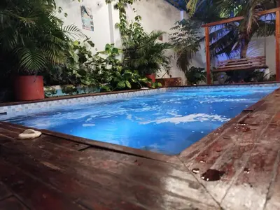 a swimming pool in a house with blue water at Hb5 Family Room with private bathroom facing the sea in Cartagena de Indias