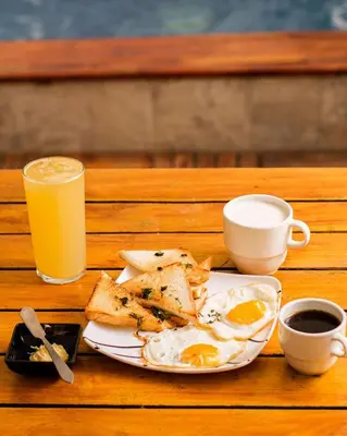 a plate of eggs and toast and a glass of orange juice at Hb7 Quadruple Room with shared bathroom in Cartagena de Indias
