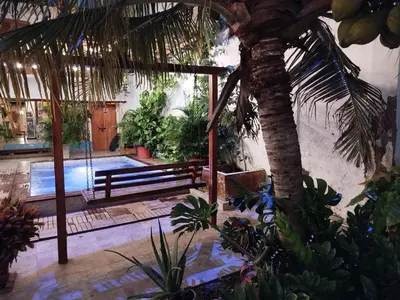 a courtyard with a palm tree and a swimming pool at Beach House In La Boquilla Facing the Sea With Air Conditioning and WIFI in Cartagena de Indias