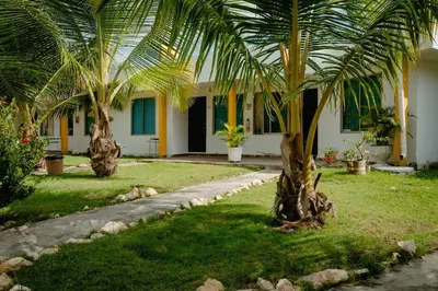 two palm trees in front of a house at Cabaña en condominio frente al mar #10 in Tolú