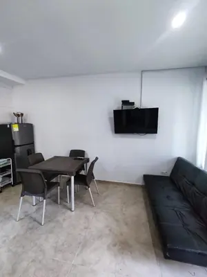 a living room with a table and chairs and a couch at Cabaña en condominio frente al mar #10 in Tolú