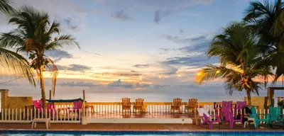 a group of chairs and tables on a balcony overlooking the ocean at Cabaña en condominio frente al mar #10 in Tolú