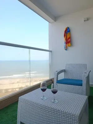 two glasses of wine sitting on a table in front of a window at Apartamento Frente al Mar Amoblado Cartagena in Cartagena de Indias