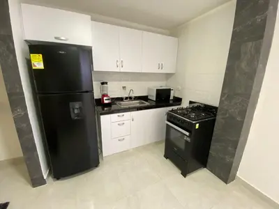 a kitchen with a black refrigerator and a sink at lindo Apartamento completo in Cartagena de Indias