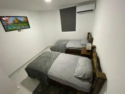 a room with two beds and a tv on the wall at lindo Apartamento completo in Cartagena de Indias