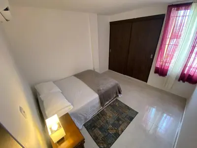 a small bedroom with a bed and a table with a lamp at lindo Apartamento completo in Cartagena de Indias