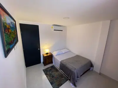 a small bedroom with a bed and a night stand at lindo Apartamento completo in Cartagena de Indias