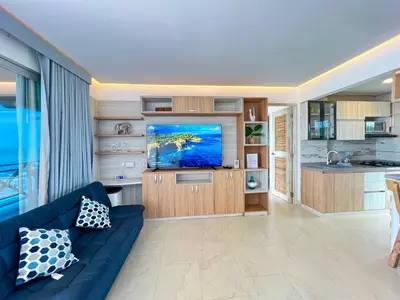 a living room with a blue couch and a tv at Hermosa Suite frente al mar en Tolu-Sucre in San Silvestre