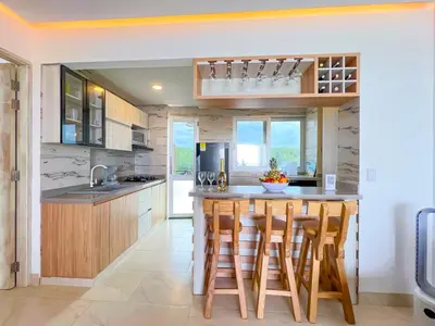 a kitchen with a large island with bar stools at Hermosa Suite frente al mar en Tolu-Sucre in San Silvestre