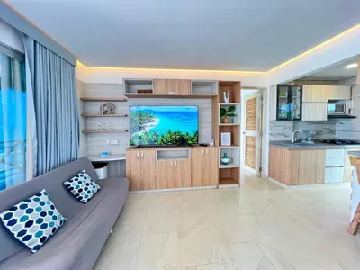 a living room with a couch and a flat screen tv at Hermosa Suite frente al mar en Tolu-Sucre in San Silvestre