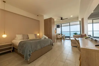 a bedroom with a bed and a kitchen and a desk at Panoramic Oceanview Loft Near Beach & Airport in Cartagena de Indias