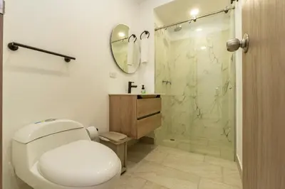 a bathroom with a toilet and a glass shower at Panoramic Oceanview Loft Near Beach & Airport in Cartagena de Indias