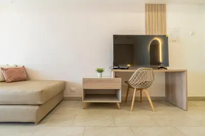 a living room with a couch and a desk with a tv at Panoramic Oceanview Loft Near Beach & Airport in Cartagena de Indias