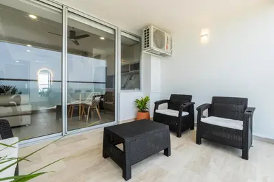 a living room with two chairs and a table at Panoramic Oceanview Loft Near Beach & Airport in Cartagena de Indias
