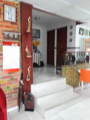 a living room with stairs and a brick wall at B&B Grand Royal Inn in Barranquilla