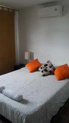 a bed with orange and orange pillows on it at B&B Grand Royal Inn in Barranquilla