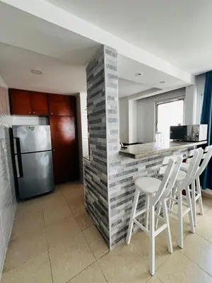 a kitchen with a counter with stools and a refrigerator at APTO 802 VISTA AL MAR in Cartagena de Indias