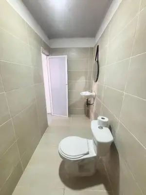 a bathroom with a white toilet and a door at Cabaña Palma Azul in Coveñas