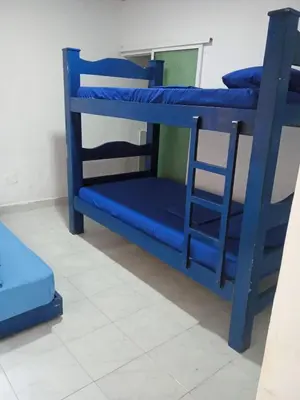 a blue bunk bed with a chair in a room at Cabaña Palma Azul in Coveñas