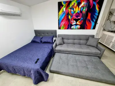 a bedroom with a bed and a painting of a lion at Apartamento Cerca al Faro y la Playa in Puerto Colombia