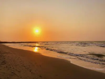 a sunset on a beach with the ocean at Apartamento Cerca al Faro y la Playa in Puerto Colombia