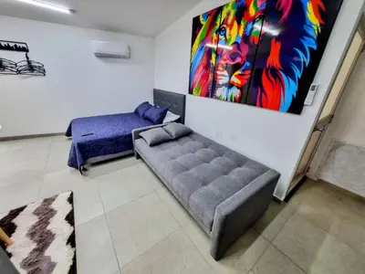 a living room with a couch and a painting on the wall at Apartamento Cerca al Faro y la Playa in Puerto Colombia