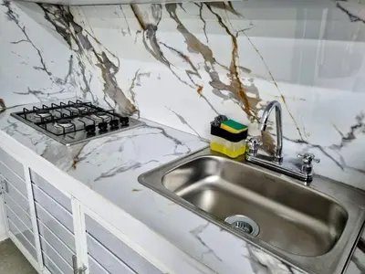 a kitchen counter with a sink and a stove at Apartamento Cerca al Faro y la Playa in Puerto Colombia