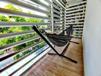 a hammock in a room with blinds at Apartamento Cerca al Faro y la Playa in Puerto Colombia