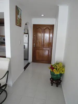 a hallway with a door and a vase of flowers at Magia frente al Mar Caribe in Cartagena de Indias