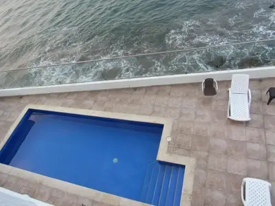 a swimming pool on a patio next to the water at Magia frente al Mar Caribe in Cartagena de Indias