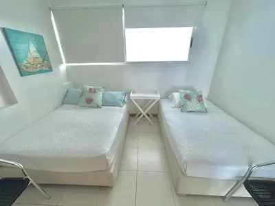 two beds in a small room with a window at Apartamento con vista al mar en Coveñas in Coveñas