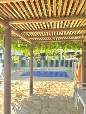a wooden pergola next to a swimming pool at Apartamento con vista al mar en Coveñas in Coveñas