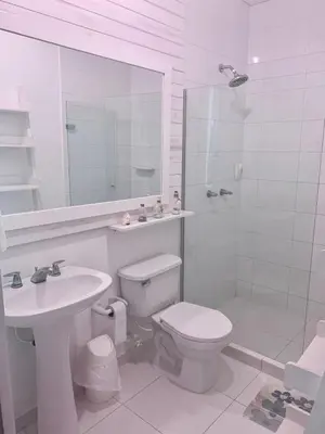 a white bathroom with a toilet and a sink at Apartamento con vista al mar en Coveñas in Coveñas