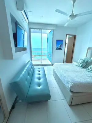 a bedroom with a bed and a couch and the ocean at Apartamento con vista al mar en Coveñas in Coveñas