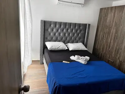 a bedroom with a blue bed with towels on it at AQUALINASTAR in Cartagena de Indias
