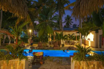 a resort pool with people swimming in it at night at Hotel Palma Grande by Stanza in Coveñas
