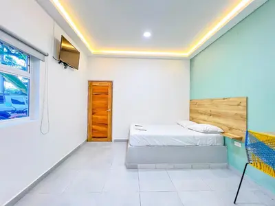 a bedroom with white walls and a bed and a window at Hotel Palma Grande by Stanza in Coveñas