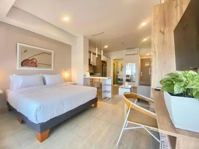 a bedroom with a large bed and a kitchen at Wynwood Cartagena Beach in Cartagena de Indias
