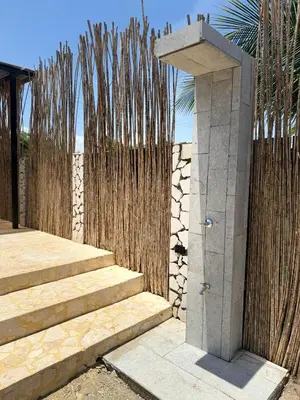 a wooden fence with stairs and a stone pillar at JERUSALEMA BEACH GLAMPING in Tolú