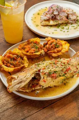 a table with two plates of food and a glass of orange juice at JERUSALEMA BEACH GLAMPING in Tolú