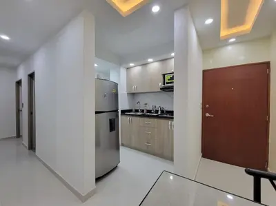 a kitchen with a stainless steel refrigerator and wooden cabinets at Apartamento cerca al Mar, en Cartagena COL in Cartagena de Indias