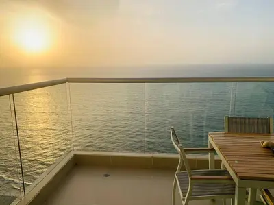 a balcony with a table and chair and the ocean at Apartament Bocagrande Palmetto Beach Front 3204 in Cartagena de Indias