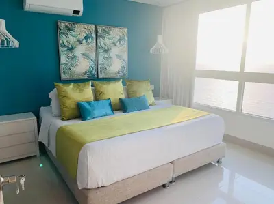 a bedroom with a large bed with blue walls at Apartament Bocagrande Palmetto Beach Front 3204 in Cartagena de Indias