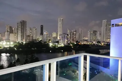a view of a city at night from a balcony at Confort en la zona del Laguito in Cartagena de Indias