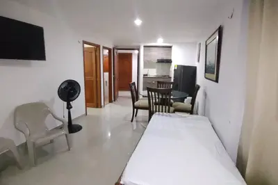a room with a bed and a table and chairs at Confort en la zona del Laguito in Cartagena de Indias