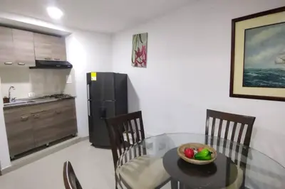 a kitchen with a glass table with a bowl of fruit on it at Confort en la zona del Laguito in Cartagena de Indias