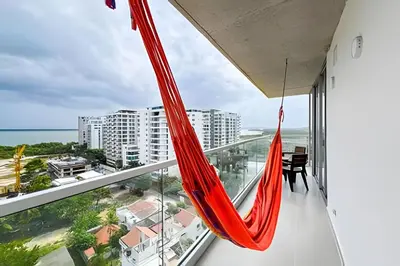 a hammock on a balcony with a view of the ocean at Apartamento 2 dormitorios Morros Vistas. Piscina in Cartagena de Indias